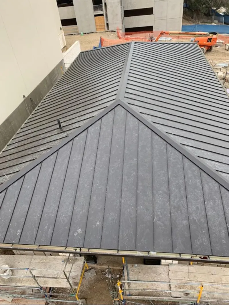 Commercial metal roof construction with crane equipment in Lockhart